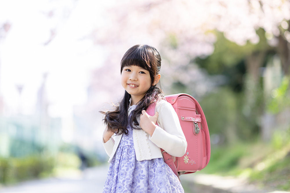 入学式にランドセルを持ってポーズをとる女の子