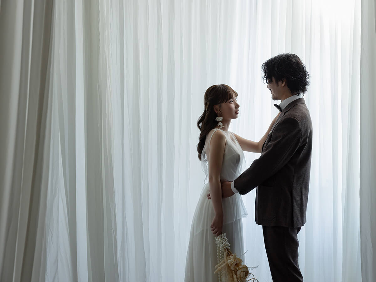 ポーズをとる洋装の新郎新婦